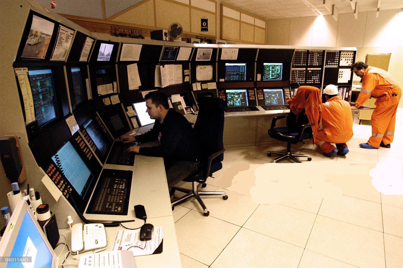 Operators aan het werk in een controlekamer van een raffinaderij