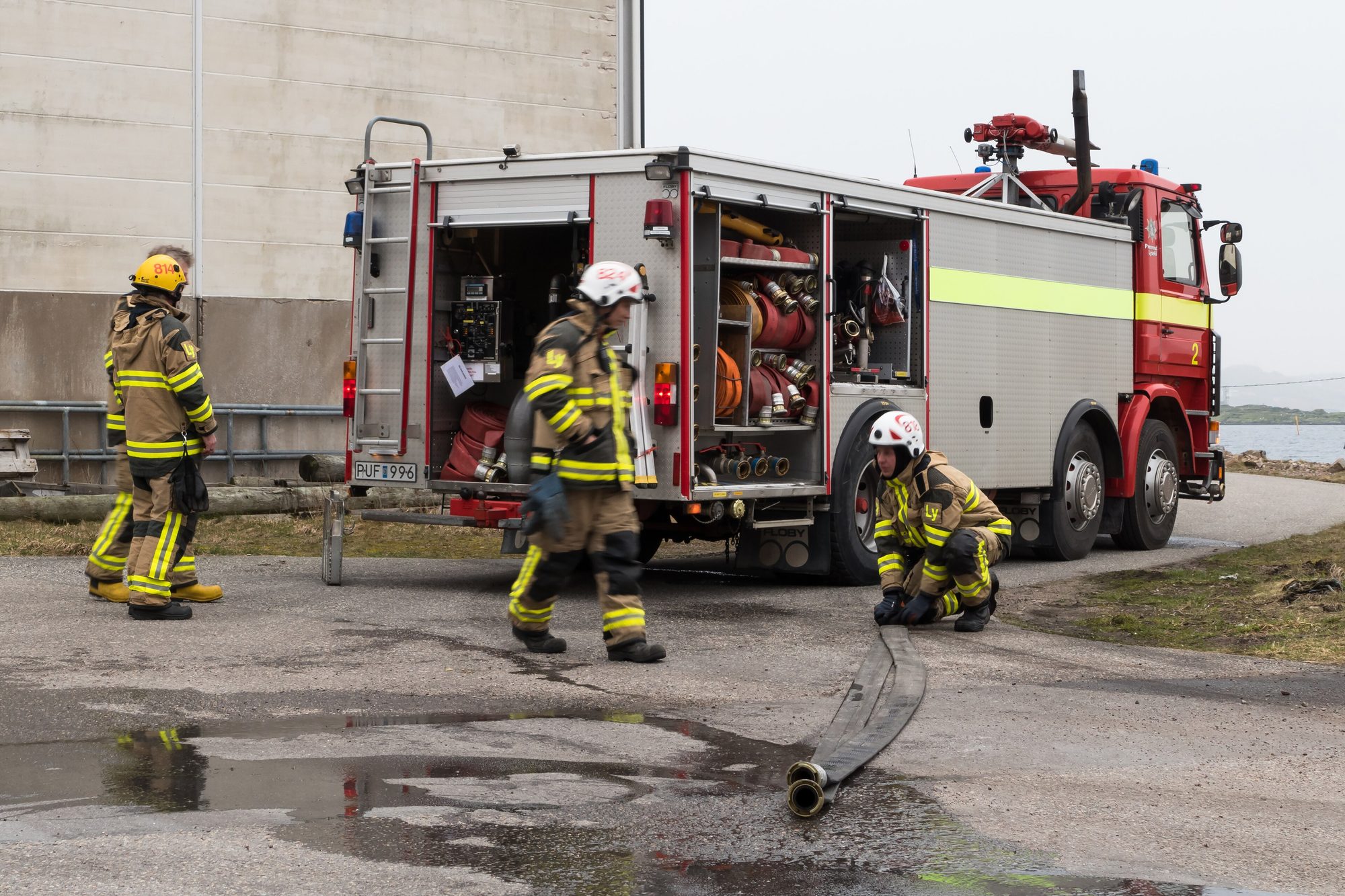 Bedrijfsbrandweer van een raffinaderij oefent met brandweerwagen en slangen